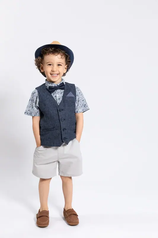 Boy in a waistcoat, bow tie and cap, white background