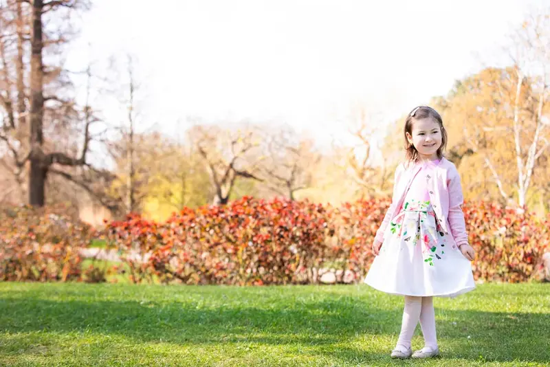 Girl in a white dress standing in a park in autumn