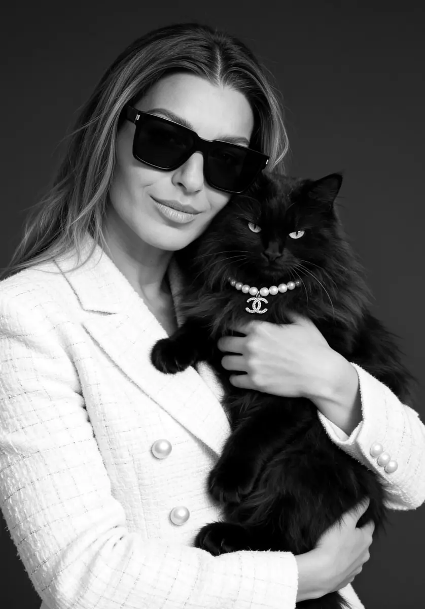 Darina Tsvetkova, photographer, in a white jacket holding a black cat