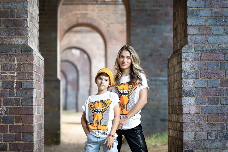 Family of four standing together in an old brick archway