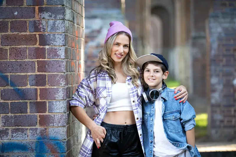 Family of four in denim standing against a brick wall
