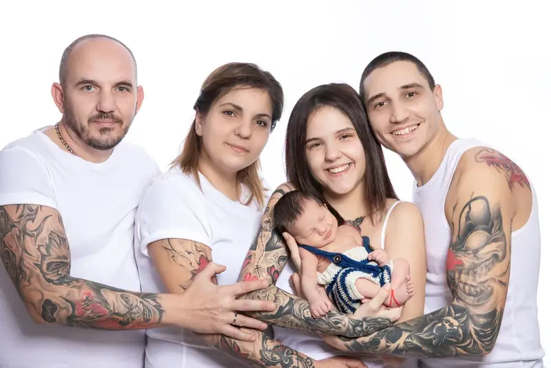 Extended family of four adults with a newborn, white background