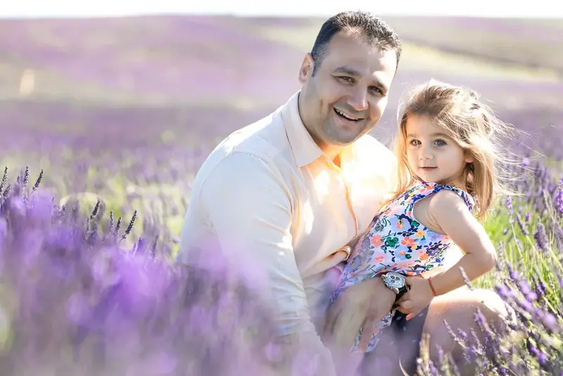 Father and young daughter in a lavender field at sunset