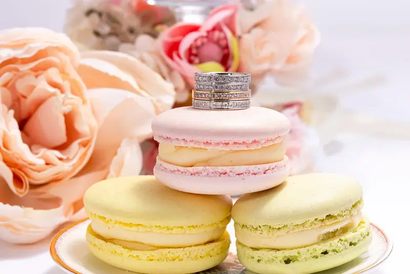 Diamond ring on a pink macaron with peach roses