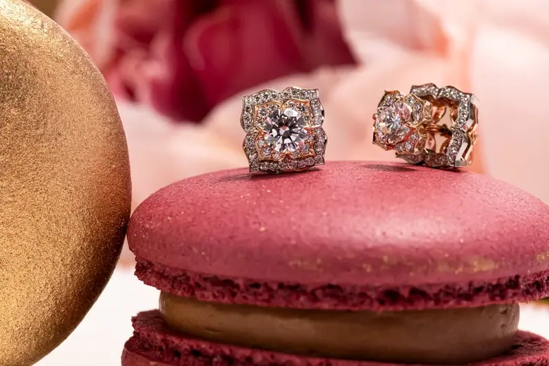 Pair of gemstone earrings resting on a red macaron