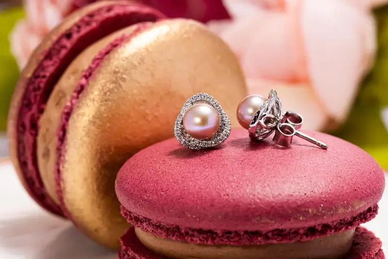 Pearl and diamond earrings on a red macaron