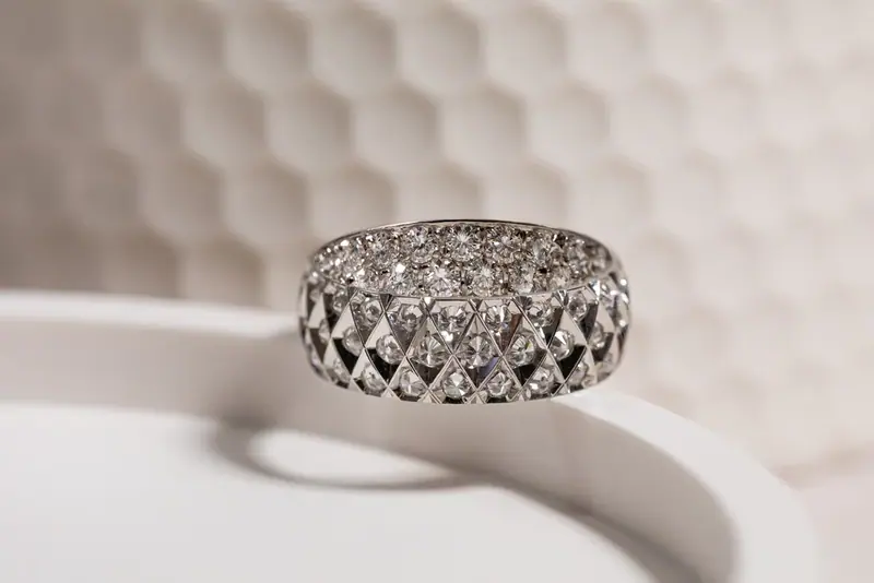 Diamond-set band ring on a white textured surface