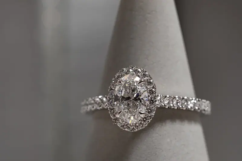 Diamond halo ring on a grey ring stand, close-up