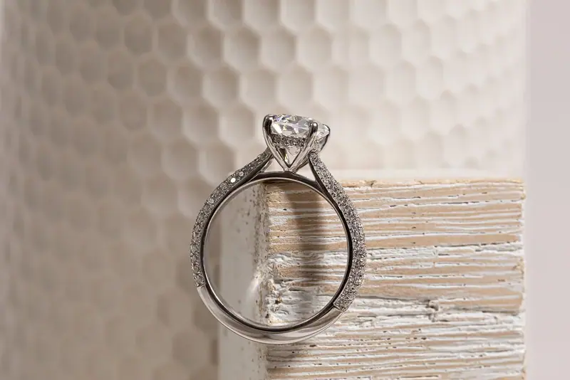 Diamond solitaire ring standing on the edge of a white block