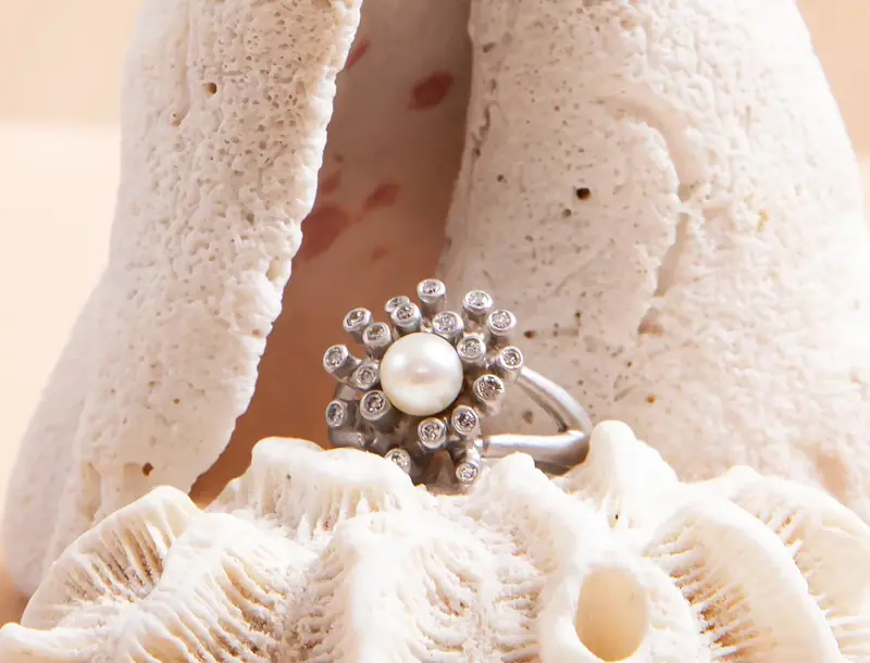 Pearl and diamond ring nestled in white coral