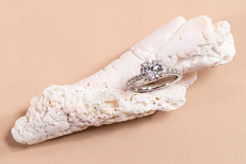 Diamond ring resting on a piece of white coral