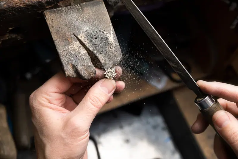 Jeweller's hands filing a ring at a workbench