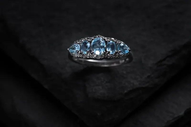 Blue gemstone ring on black slate, close-up