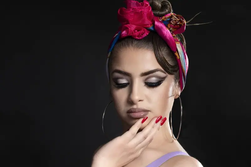 Close-up of a woman with a pink flower headband and red nails, eyes closed
