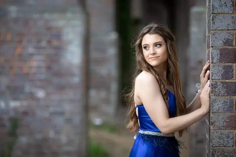 Woman in a blue dress standing in an old brick archway