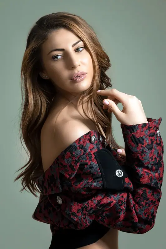 Woman in a patterned off-the-shoulder top, outdoor portrait with a soft background