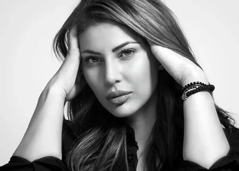 Black and white headshot of a woman with her hand in her hair