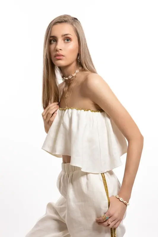 Blonde woman in a white two-piece outfit, white background