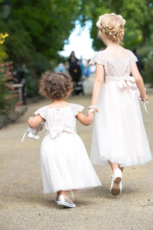 Bridesmaid and a small flower girl walking along a path