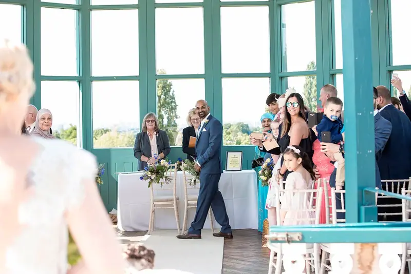 Wedding guests gathered in a light-filled conservatory