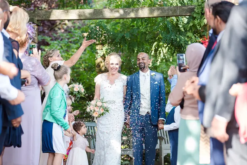 Newlyweds showered with confetti by guests outdoors