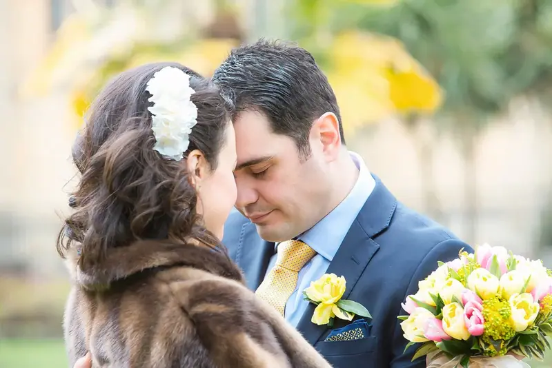 Bride in a fur stole and groom with a bouquet of tulips, close together