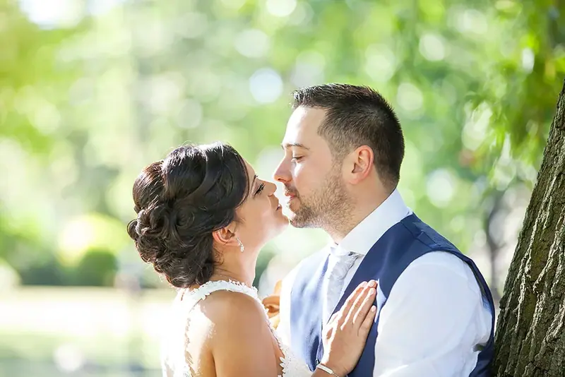 Bride and groom in profile about to kiss, outdoors